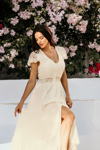 cream dress in front of flowers
